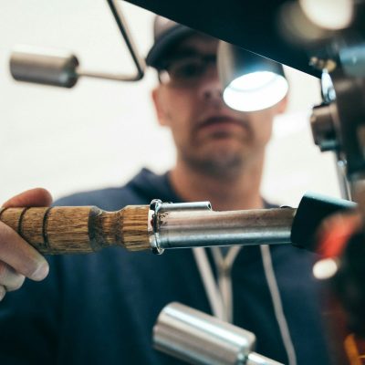 man wearing black pullover hoodie holding tool
